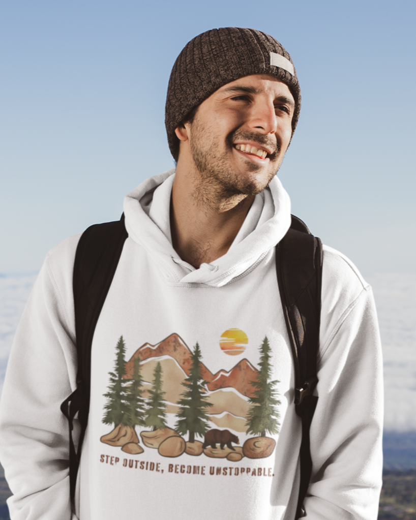 Guy exploring nature in the Mountain Bear Hoodie featuring a bear and 'Step Outside, Become Unstoppable' design.