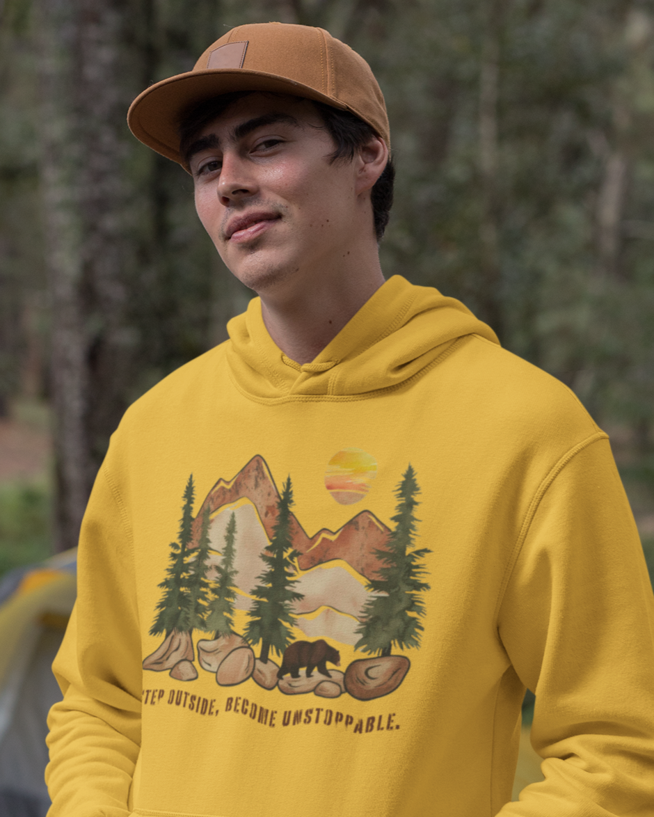 Young adventurer wearing the hoodie with the motivational phrase 'Step Outside, Become Unstoppable'